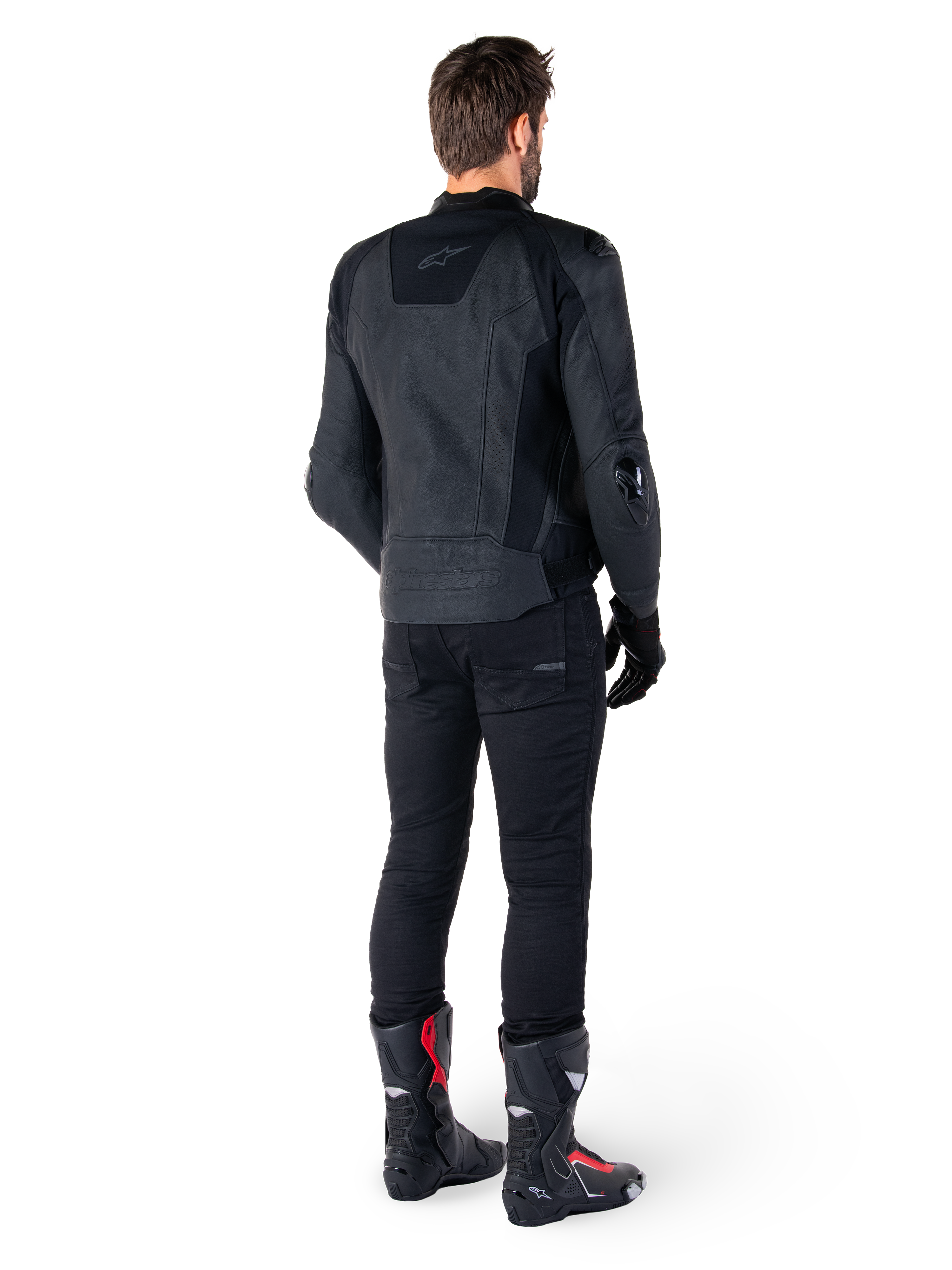 Alpinestars Missile V3 Leather Jacket in Black, rear view on a rider, worn with black pants and black and red racing boots, featuring sleek leather construction with tonal branding and a performance race fit