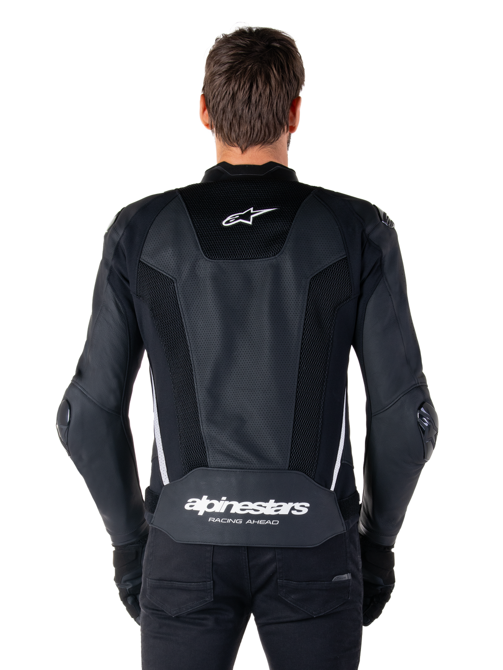 Alpinestars Missile V3 Airflow Leather Jacket, Black and White, back view worn by a rider, featuring extensive perforated leather panels, white side accents, Alpinestars star logo on the upper back, and 'alpinestars RACING AHEAD' branding on the lower back.