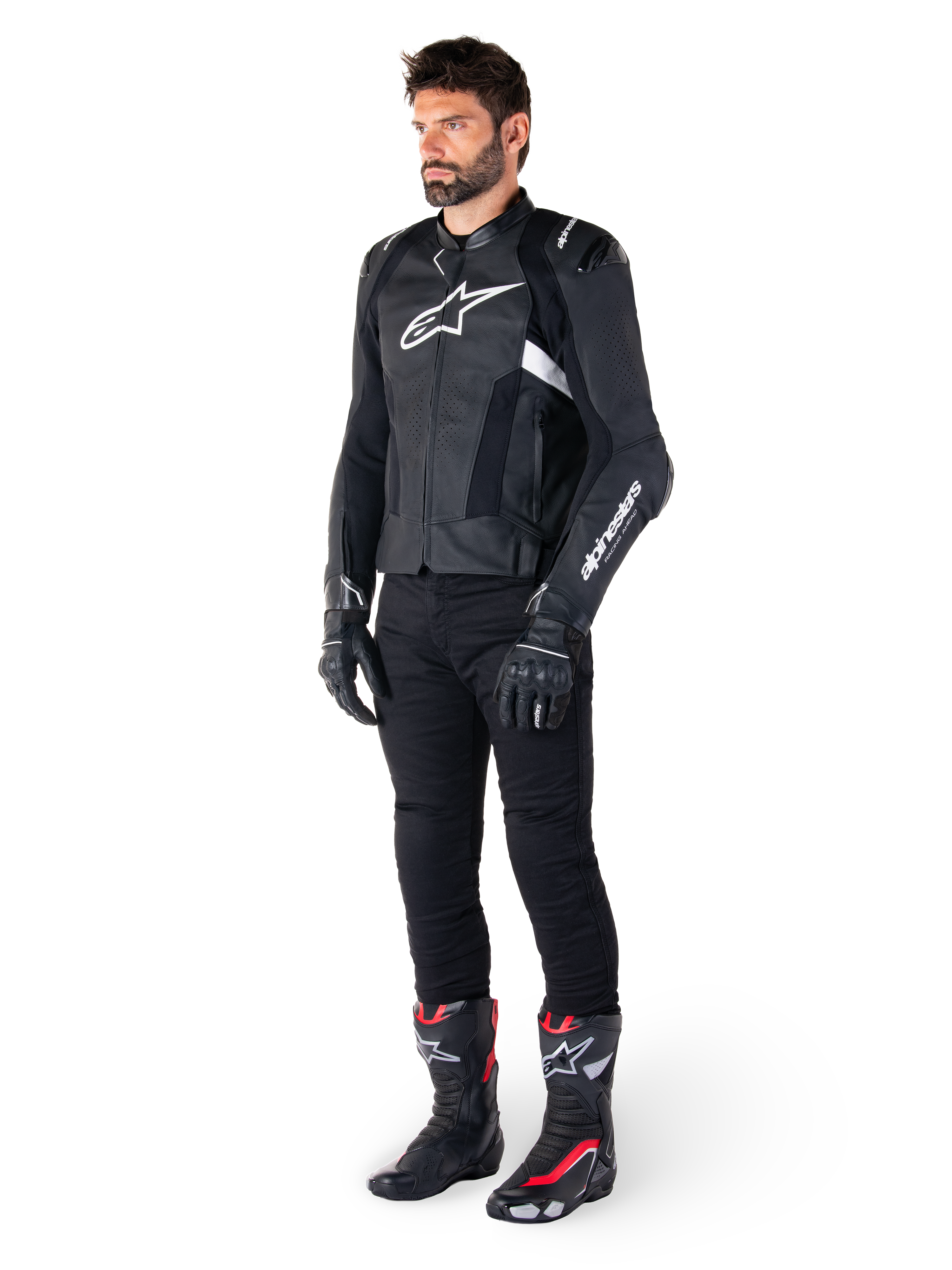 Alpinestars Missile V3 Airflow Leather Jacket, Black and White, worn by a male model with black riding pants, black gloves, and racing boots with red and white accents, featuring perforated leather and white logo branding, performance motorcycle racing gear