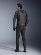 Rear view of a model wearing the Alpinestars GP Force V2 Leather Jacket in Black Black, featuring a multi-panel leather construction and sport fit, paired with black riding pants, gloves, and boots for a full motorcycle racing-inspired look.