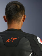 Alpinestars GP Force V2 Leather Jacket, Black and White, close-up view from behind of the neck and shoulders, red Alpinestars logo, premium leather with textile stretch panels, sporty performance design
