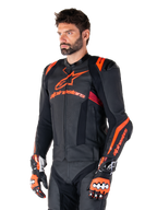 Alpinestars Missile V3 Ignition Leather Jacket, Black with Red Fluo and Dark Red accents, worn by a male model with matching racing gloves and leather pants, featuring bold Alpinestars branding, perforated leather panels, and external shoulder protectors, professional motorcycle racing gear