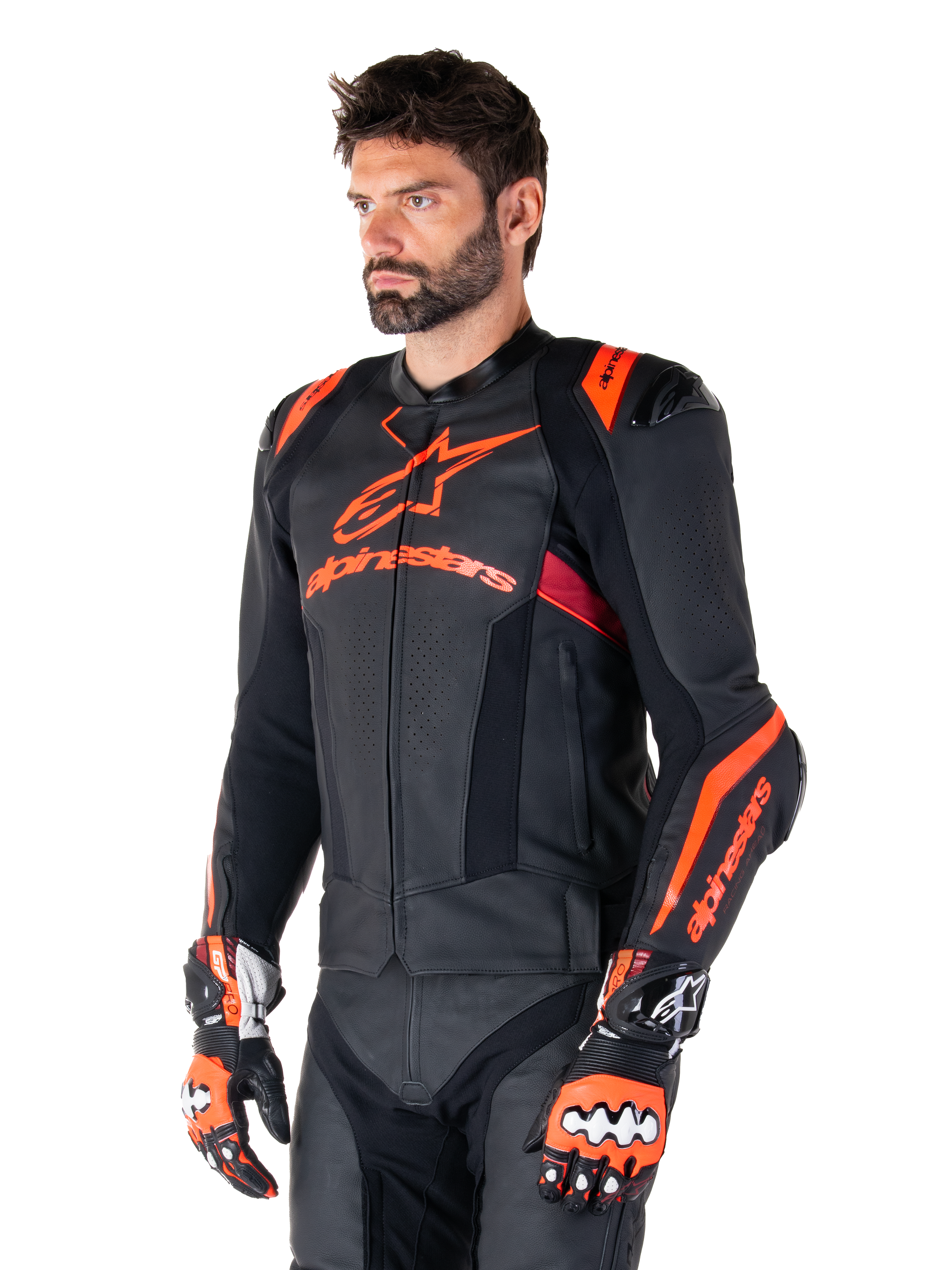 Alpinestars Missile V3 Ignition Leather Jacket, Black with Red Fluo and Dark Red accents, worn by a male model with matching racing gloves and leather pants, featuring bold Alpinestars branding, perforated leather panels, and external shoulder protectors, professional motorcycle racing gear
