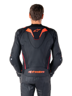 Alpinestars Missile V3 Ignition Leather Jacket, Rear View, Black with Red Fluo and Dark Red accents, featuring a sport aero-hump, Alpinestars branding on the back, worn with matching black leather riding pants, performance motorcycle racing gear