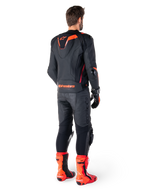 Alpinestars Missile V3 Ignition Leather Jacket, Racing Sport Motorcycle Jacket, Black and Red Fluo, rear view of a rider wearing a full racing outfit with matching leather pants, gloves, and red boots, featuring a sport Aero-hump and bold branding on the lower back.