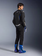 Model from the back wearing the Alpinestars GP Force V2 Airflow Leather Jacket in Black Metallic Blue, featuring perforated leather panels and white logos, paired with matching racing gloves and blue boots, sport-focused riding gear.