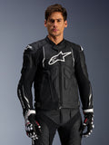 Alpinestars Dusk Leather Jacket, Black and White, leather motorcycle jacket with padded protection areas and white logos, worn with black and white racing gloves featuring red accents, professional sport riding gear