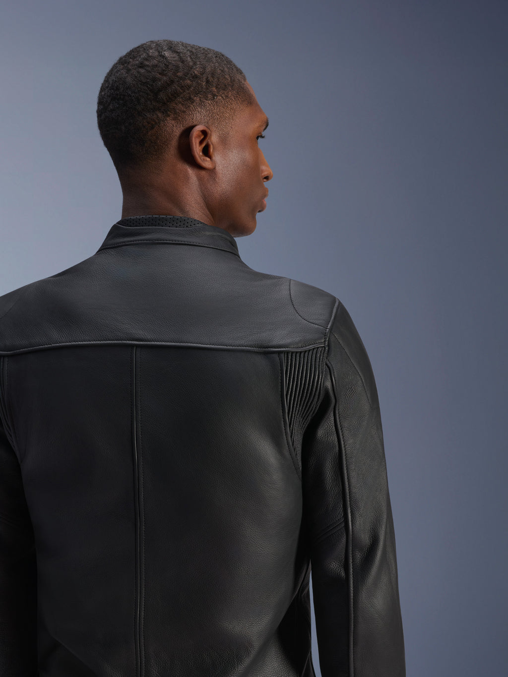 Alpinestars Blacktrack Leather Jacket, Black, premium bovine leather motorcycle jacket shown from the back, featuring leather accordion panels on the shoulder blades and a perforated collar, tailored fit for urban riding