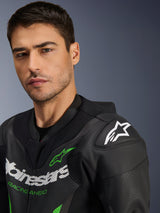 Alpinestars GP Force V2 Leather Suit - 1Piece, Black and Green, close-up of a male model wearing the motorcycle racing suit, featuring white and green logo branding, perforated leather panels, and DFS Lite shoulder armor with a white star logo.