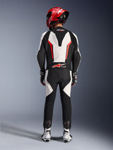 Alpinestars GP Force V2 Leather Suit - 1Piece, White Black Red Fluo, rear view highlighting the aerodynamic speed hump and Tech-Air Ready branding, worn with red racing helmet and white and black boots, track-focused leather suit for performance riding.