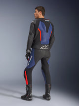 GP Force V2 Leather Suit 2-Piece, Black Blue and Red Fluo, rear profile view on a model, featuring aerodynamic hump, perforated leather, and Tech-Air Ready branding, worn with black Alpinestars racing boots and gloves