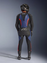 Alpinestars GP Force V2 Leather Suit 2-Piece, Black Blue Red Fluo, full rear view of a rider in complete racing gear, featuring blue leather panels on the back and legs with fluorescent red accents, Tech-Air® Ready logo on the lower back, paired with a carbon fiber helmet, black gloves, and racing boots.