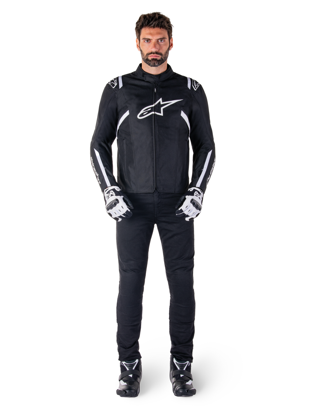 Alpinestars T-SPS V2 Waterproof Jacket, Black and White, worn by male model with black pants and matching gloves, featuring white Alpinestars logo on chest and accents on sleeves, sport-cut silhouette for all-weather motorcycle riding
