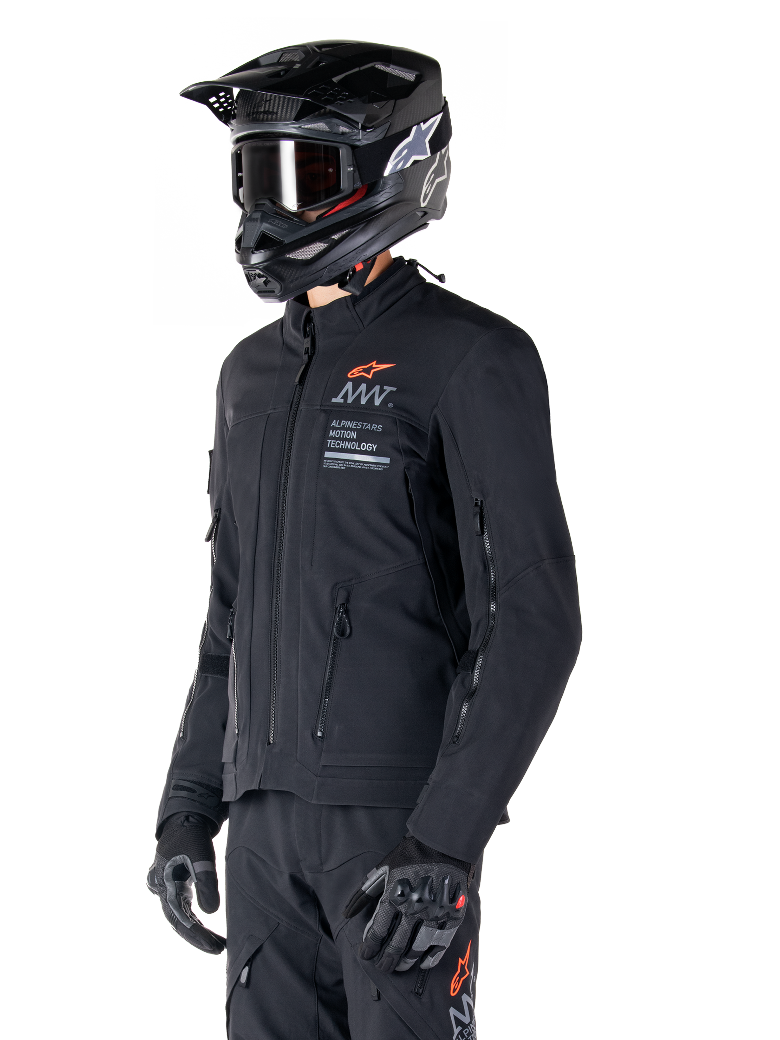 Alpinestars AMT-8 Stretch Drystar® XF Jacket, Black, worn by a rider with matching adventure pants and gloves, featuring a black motocross helmet and goggles, zippered ventilation ports on the chest and arms, Alpinestars Motion Technology branding with an orange logo, premium adventure-touring gear