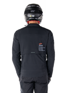 Alpinestars AMT-8 Stretch Drystar® XF Jacket, Rear View, Black, worn with a black helmet and pants, featuring Alpinestars Motion Technology branding on the back, adventure touring design with ergonomic stretch material.