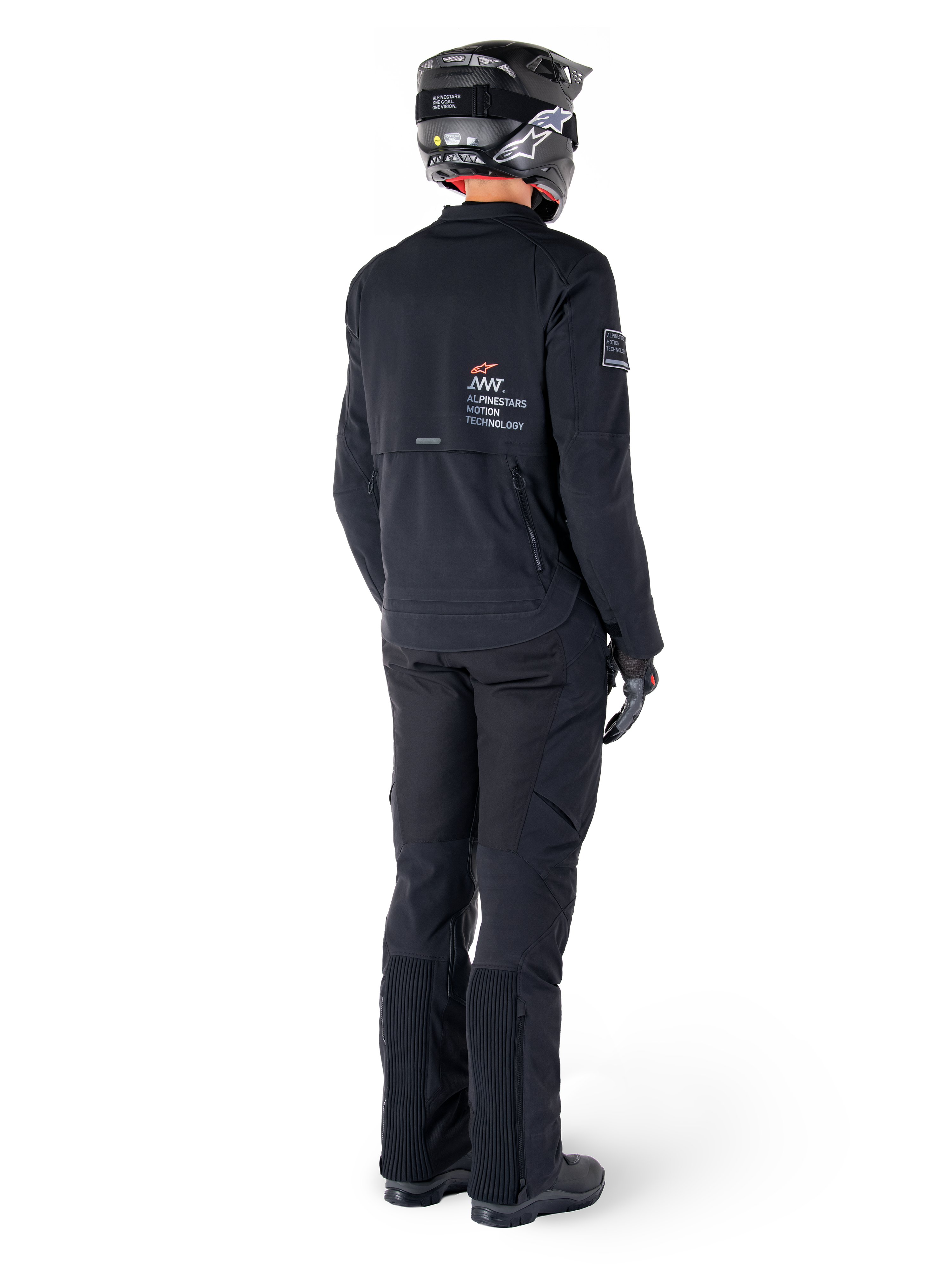 Alpinestars AMT-8 Stretch Drystar® XF Jacket, Black, rear view of a rider wearing the jacket with matching black pants and a black helmet, featuring 'Alpinestars Motion Technology' branding on the back, technical stretch material for adventure motorcycle riding