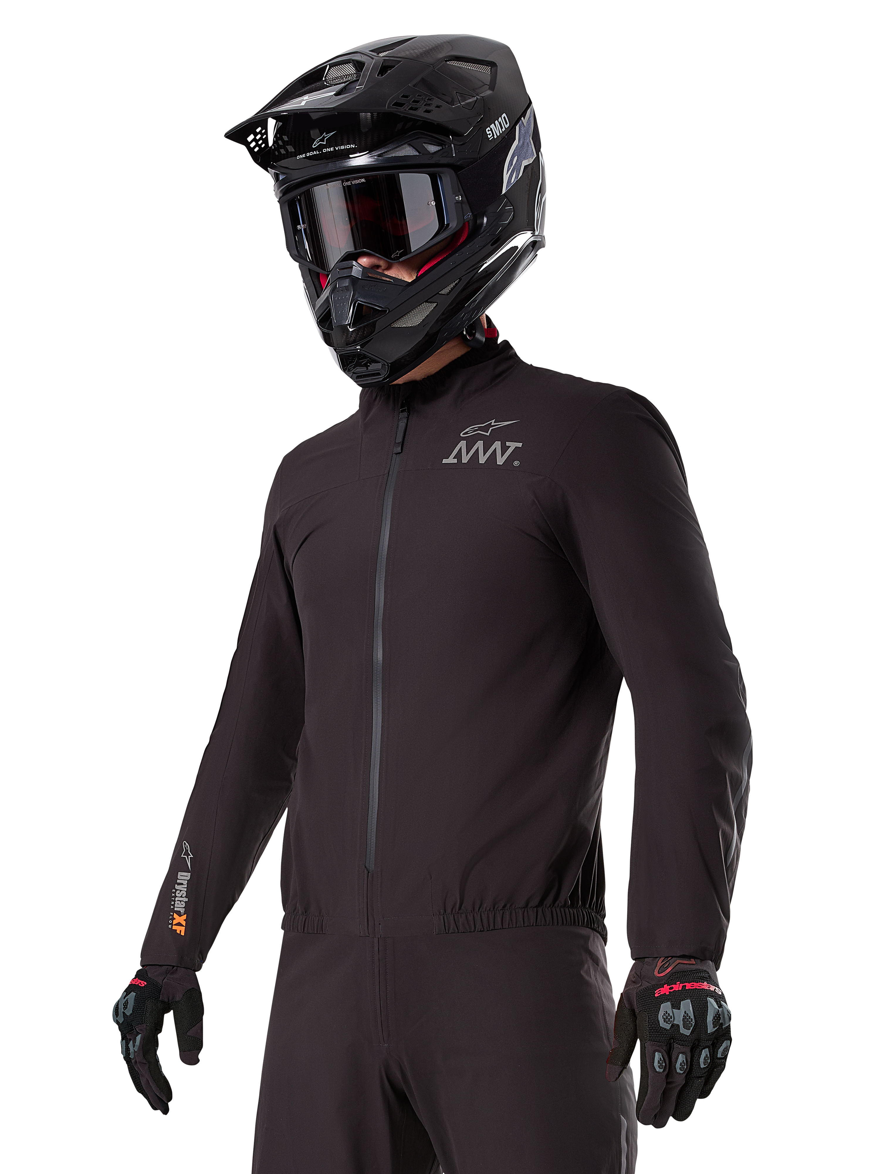 Rider wearing the Alpinestars AMT-8 Stretch Drystar® XF Liner, black windproof and waterproof stretch jacket, featuring AMT logo on the chest and Drystar XF branding on the sleeve, paired with a black adventure helmet and protective gloves.