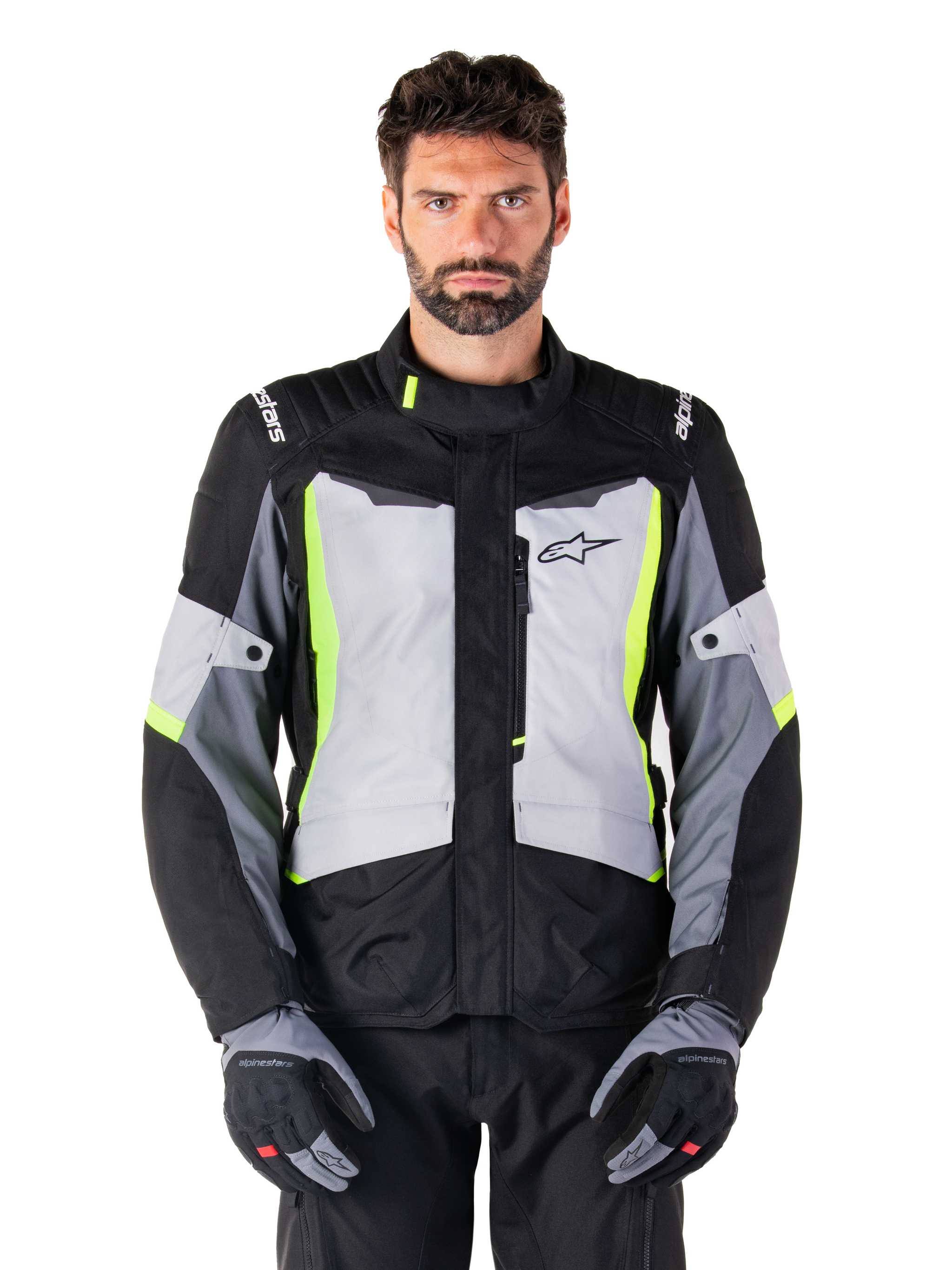 Alpinestars ST-1 Waterproof Jacket, adventure touring motorcycle jacket, Ice Gray Black and Yellow Fluo, worn by a man with matching gloves and black pants, featuring neon yellow accents on the chest and collar, Alpinestars logo on the chest