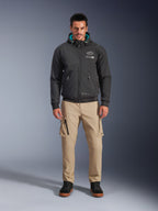 Alpinestars Moblast Waterproof Jacket, Black urban motorcycle hoodie with teal interior hood lining, worn with tan cargo pants and black high-top boots, contemporary all-season riding apparel