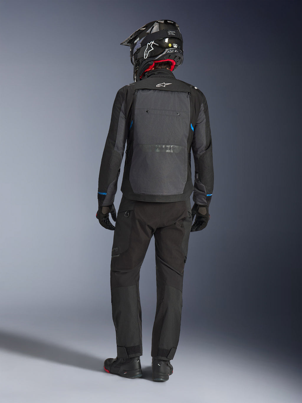 Alpinestars Cusco Drystar® Jacket, Black and Deep Gray, back view of rider wearing full adventure touring gear, large gray back panel with Alpinestars logo, blue sleeve accents, worn with matching black pants and helmet.