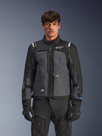 Alpinestars Cusco Drystar® Jacket, Motorcycle Touring Jacket, Black and Deep Gray, front view on model, featuring Alpinestars logos on chest and shoulders, Drystar® sleeve branding, technical multi-pocket design with ventilation zippers, paired with black riding gear