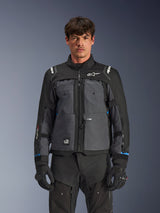 Alpinestars Cusco Drystar® Jacket, Motorcycle Touring Jacket, Black and Deep Gray, front view on model, featuring Alpinestars logos on chest and shoulders, Drystar® sleeve branding, technical multi-pocket design with ventilation zippers, paired with black riding gear