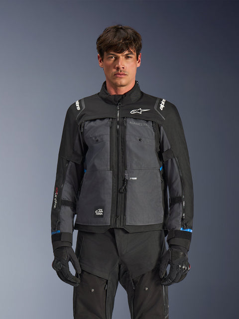 Alpinestars Cusco Drystar® Jacket, Motorcycle Touring Jacket, Black and Deep Gray, front view on model, featuring Alpinestars logos on chest and shoulders, Drystar® sleeve branding, technical multi-pocket design with ventilation zippers, paired with black riding gear