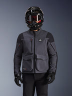 Alpinestars Maxdura Drystar®XF Laminated Armored Shell, Motorcycle Jacket, Deep Gray and Black, worn by a rider with a black helmet, goggles, and gloves, featuring large technical cargo pockets and ALL TERRA branding, adventure touring gear