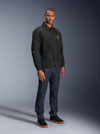 Alpinestars Revved WR Jacket in Black, urban coaches-style motorcycle jacket worn by a model with dark blue jeans and black sneakers, featuring a snap-button front and embroidered logo, minimalist and sporty design for road riding.