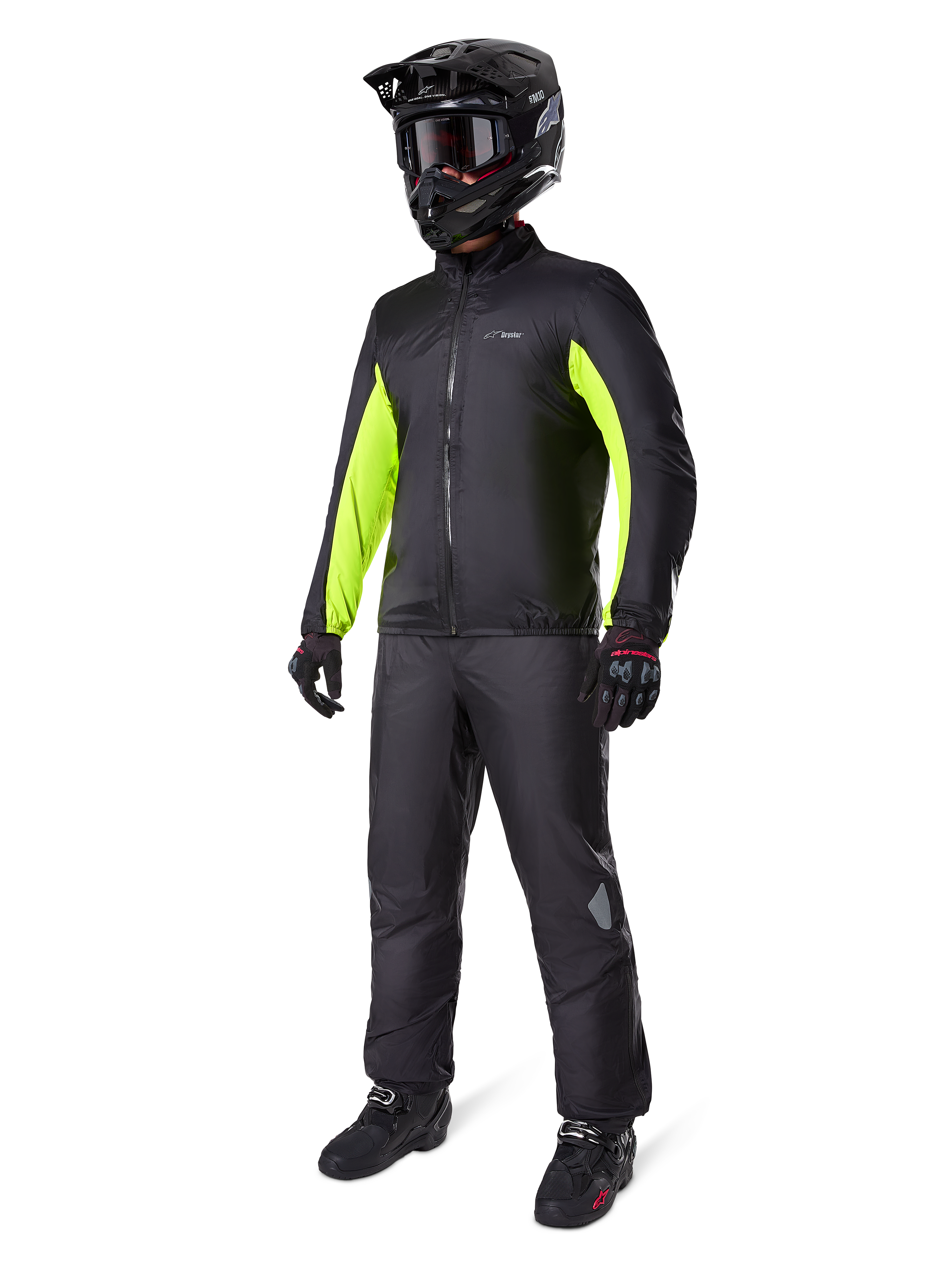 Motorcyclist wearing Alpinestars Bogotá Pro Drystar® Jacket liner, Black with bright Yellow Fluo panels on the sleeves, worn with matching black pants, black motocross helmet, and gloves, waterproof all-season adventure gear