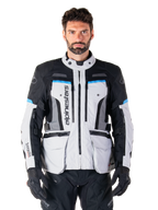 Alpinestars Bogota Pro Drystar Jacket, Motorcycle Adventure Touring Jacket, Ice Gray with Black and Cyan blue accents, front view showing ventilation panels and cargo pockets, worn by a model with black riding pants and gloves