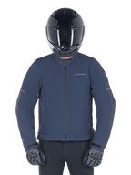 Alpinestars Husker Waterproof Jacket, Night Navy, urban motorcycle jacket worn with a black full-face helmet and grey gloves, featuring a technical softshell exterior and subtle branding