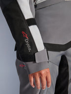 Alpinestars Stella Andes V4 Drystar® Jacket, women's gray textile adventure sleeve with logo and velcro wrist closure.