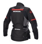 Alpinestars Women Stella Honda Andes V3 Drystar® Jacket, Motorcycle Adventure Jacket, Black Tar Gray and Bright Red, Rear view featuring bold white HONDA logo and red Alpinestars graphics, waterproof textile construction with adjustable waist and utility pockets