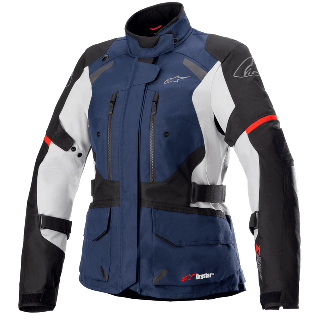 The Women Stella Andes V3 Drystar® Jacket by Alpinestars EU is a blue, black, and white motorcycle jacket equipped with visible zippers, pockets, and adjustable straps. Featuring a high collar and branding on the chest and arm, this rugged design offers waterproof capabilities and abrasion resistance for ultimate protective riding gear.