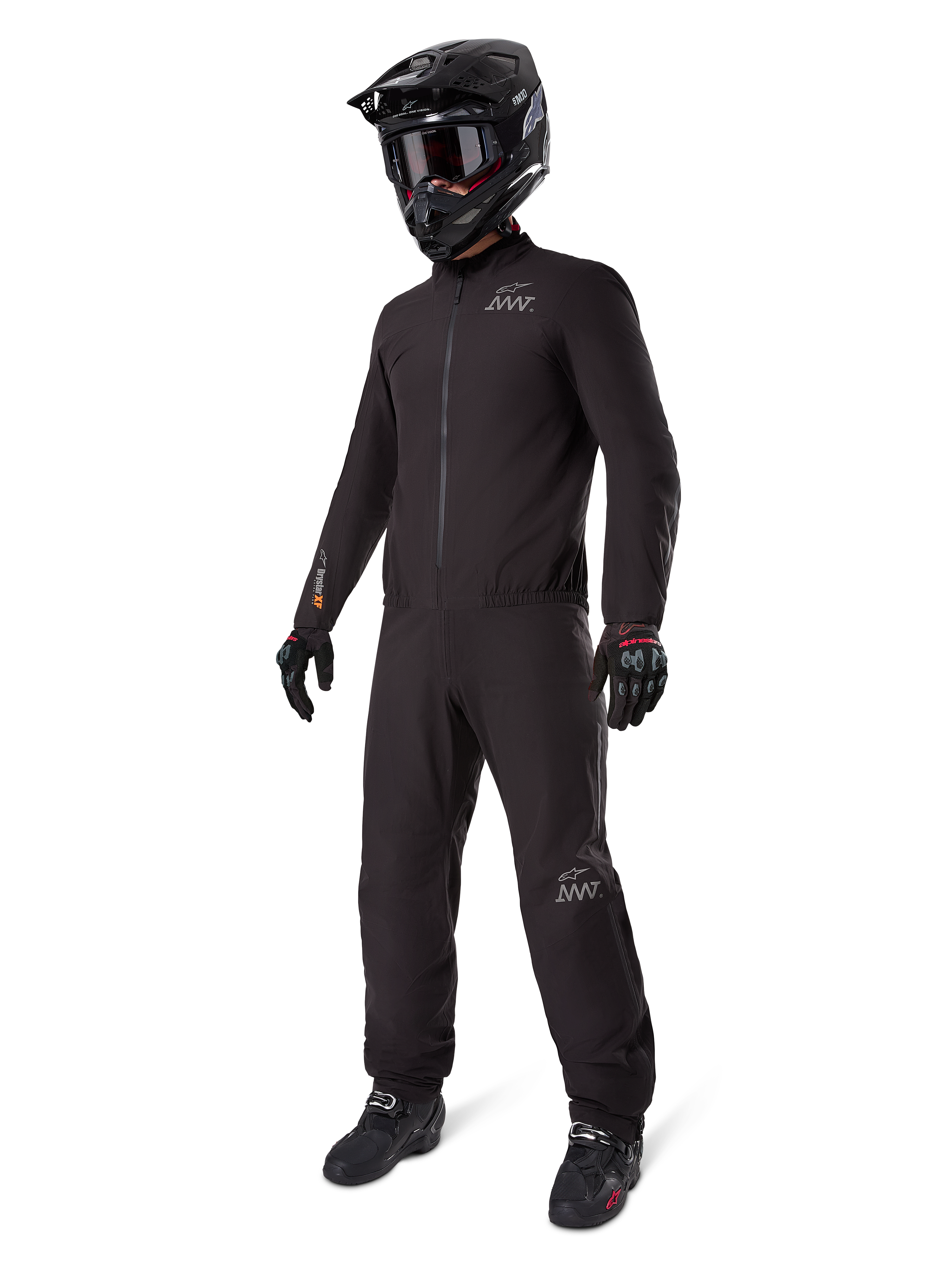 Alpinestars AMT-8 Stretch Drystar XF Liner, full black adventure touring suit, waterproof and windproof jacket and pants, paired with a black adventure helmet, goggles, gloves, and riding boots, featuring AMT logos and Drystar XF branding on sleeves and legs.