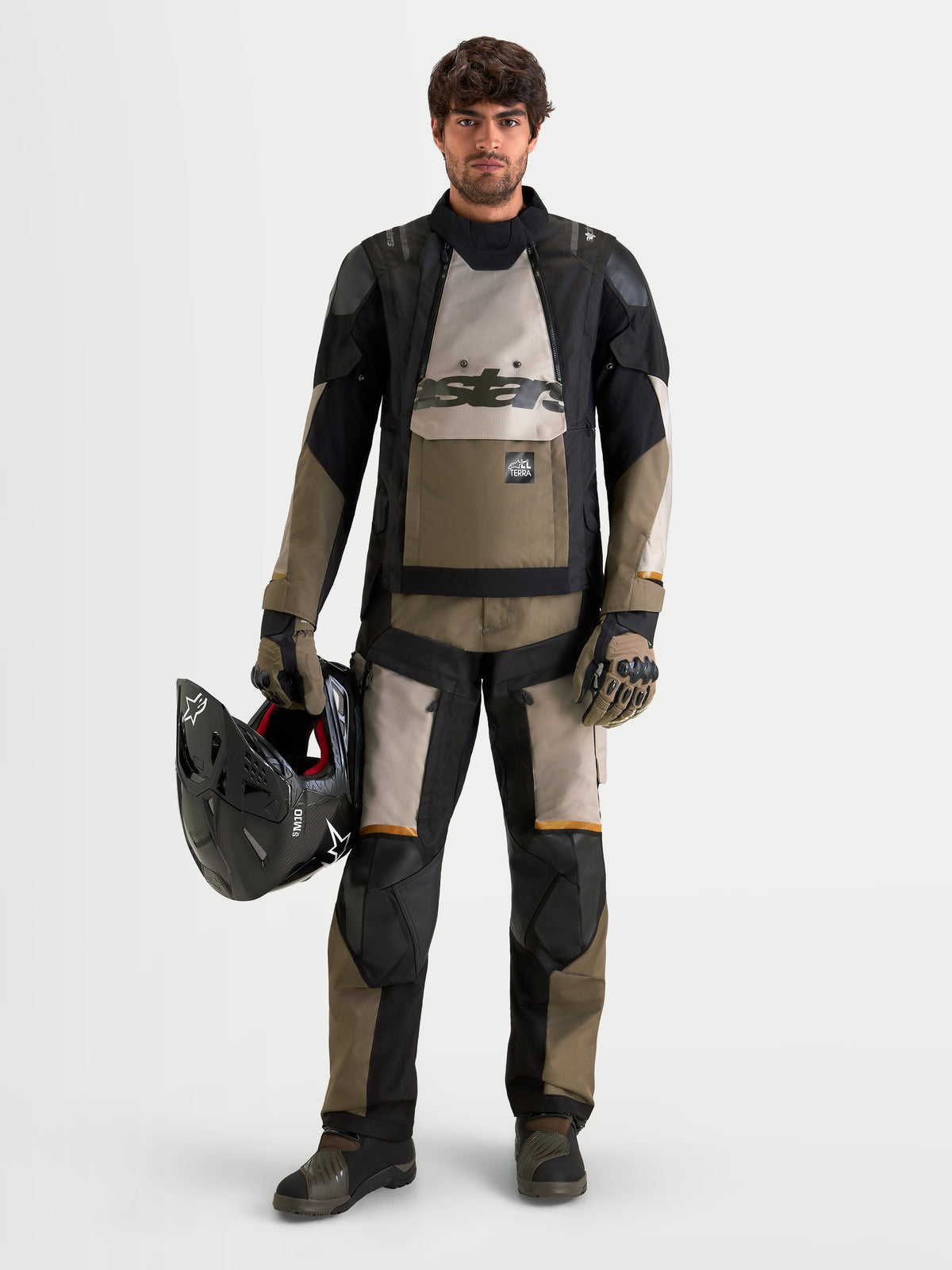 Alpinestars Harok V2 Drystar Pants, Men's All-Terra Adventure Motorcycle Pants, Aluminum, Walnut, and Black, CE Level 2 knee armor, worn by a male rider holding a helmet