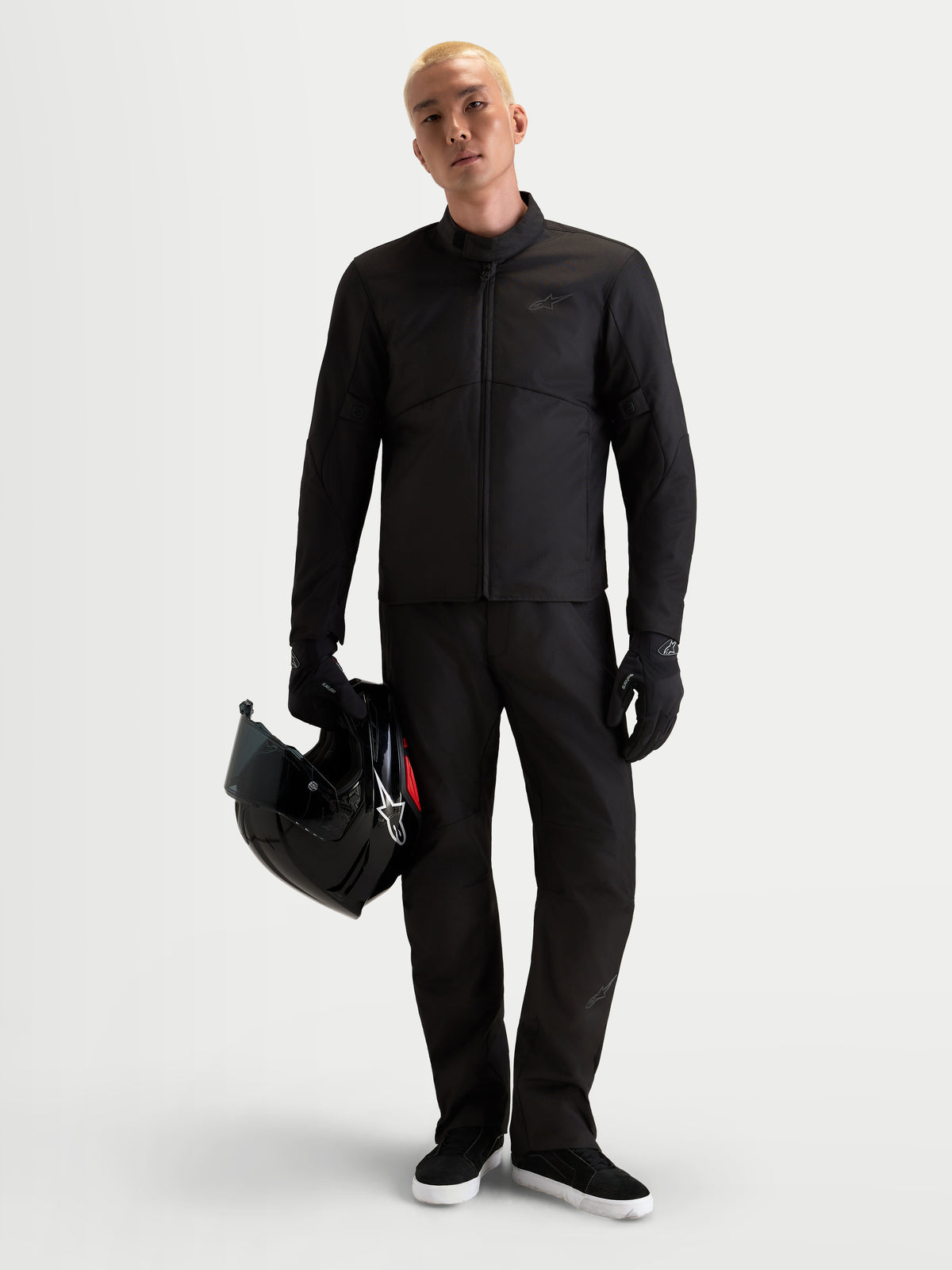 Alpinestars C-1 Waterproof Pants, men's urban motorcycle touring pants in black, straight-fit winter riding apparel with CE certified protection worn by a model holding a helmet