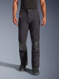 Alpinestars Halo Pro Drystar® XF Laminated Pants in Black Dark Shadow, adventure motorcycle pants, front view on model featuring magnetic waist buckle, zippered thigh vents, and reinforced leather knee patches, paired with black riding boots.