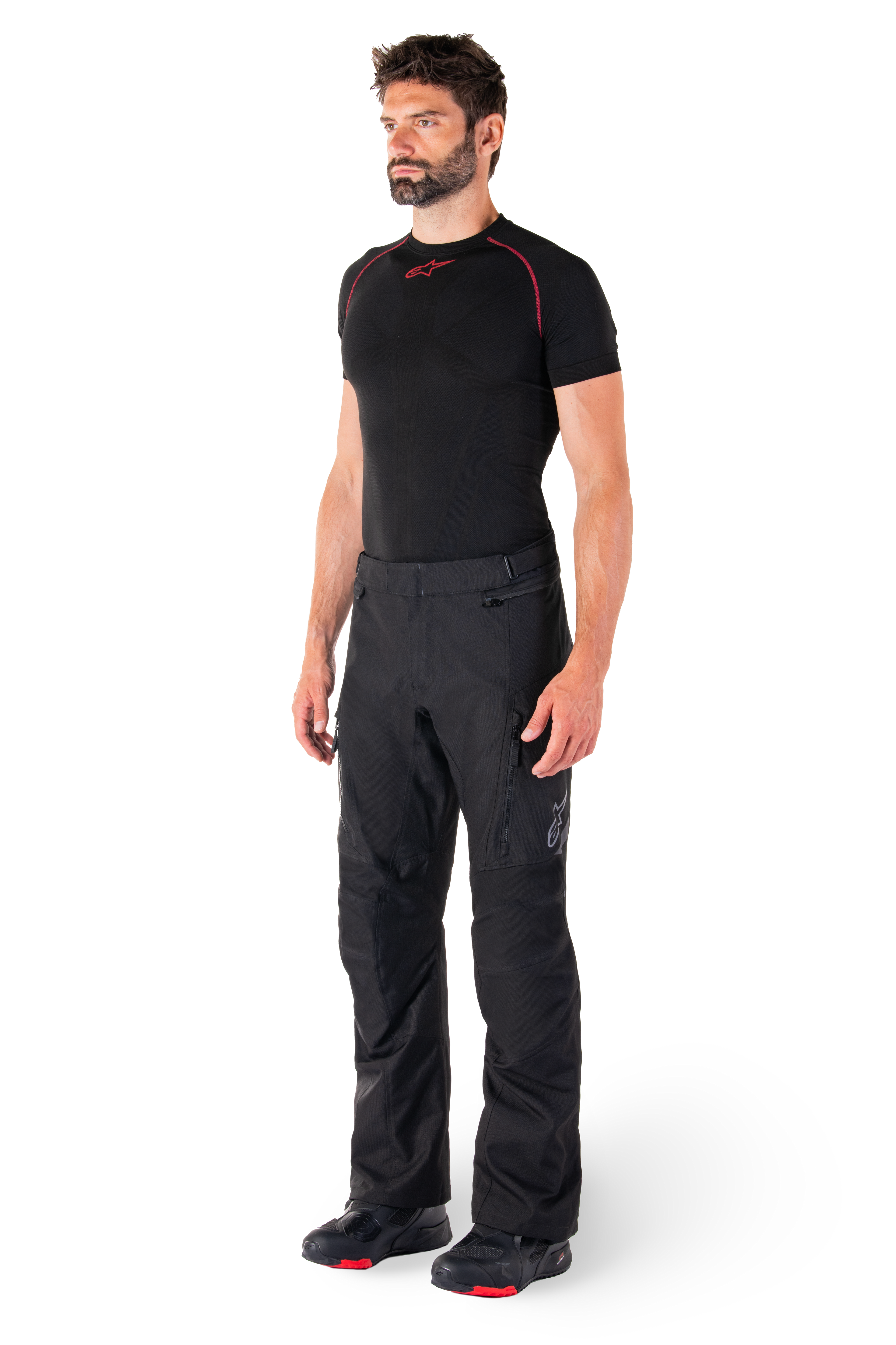 Alpinestars St-1 Waterproof Pants, Black, Adventure Touring Motorcycle Pants worn by a model with a black base layer and riding boots, featuring zippered pockets and reflective accents, durable textile construction for all-weather performance