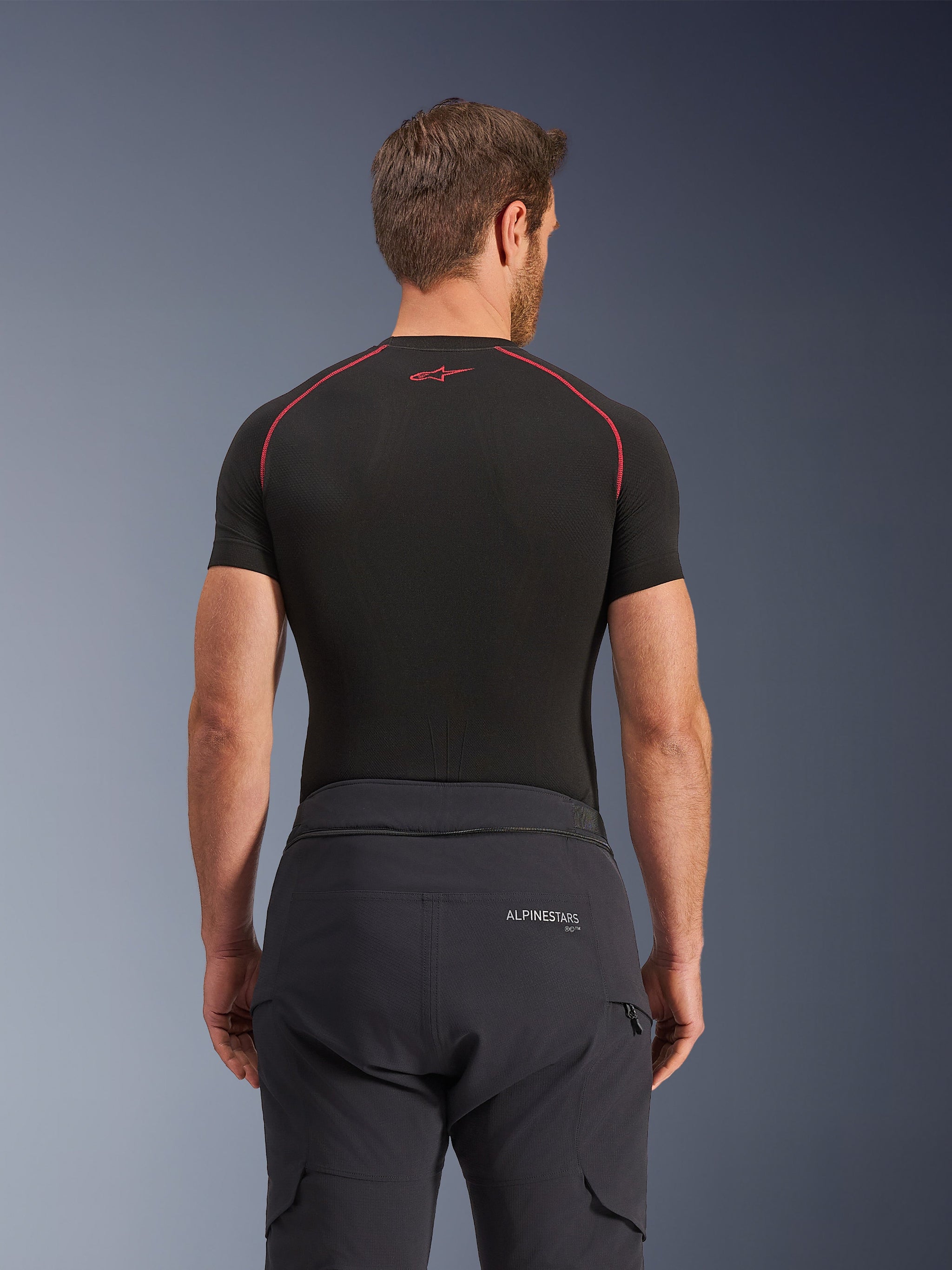 Alpinestars Andes Pro Drystar® XF Pants, Adventure Touring Pants, Black Dark Gray, rear view showing waist branding and jacket connection zipper, worn with a black short-sleeve base layer featuring red stitching