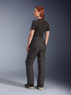 Alpinestars Stella Andes V4 Drystar® Pants, Black, adventure motorcycle pants shown from a rear side angle on a model, paired with a black t-shirt and boots, featuring side cargo pockets with white logo branding and durable textile construction.