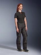 Alpinestars Stella Andes V4 Drystar® Pants, Women's Motorcycle Pants, Black, worn with a black short-sleeve t-shirt with a red logo and technical shoes, adventure touring design with reinforced panels and ventilation zips, full-length three-quarter view