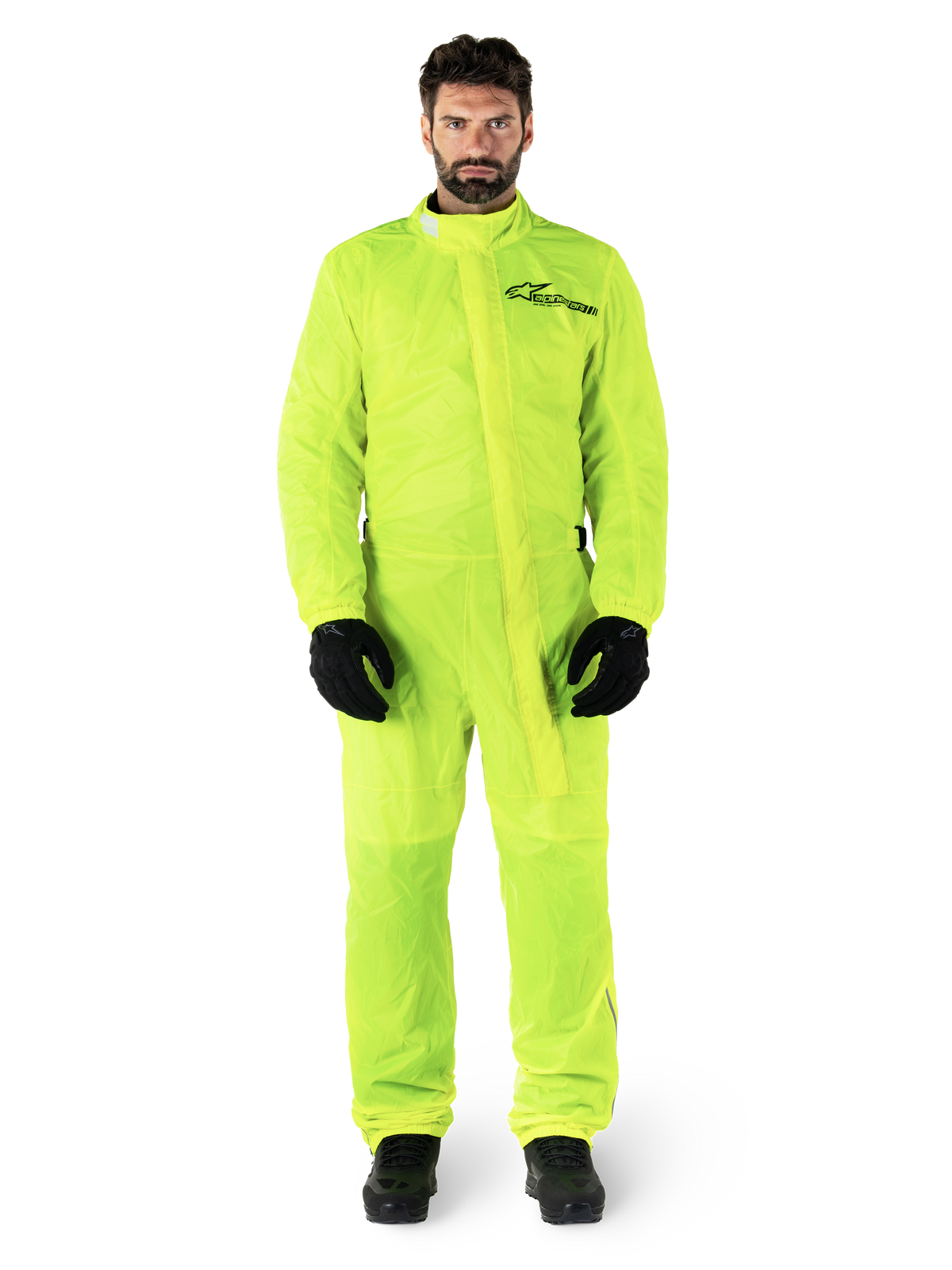 Alpinestars Hurricane Rain V2 Suit, Motorcycle Rain Suit, Yellow Fluo, male model wearing full-body protection with black gloves and boots, high collar with front storm flap, reflective logo on chest, high-visibility waterproof gear