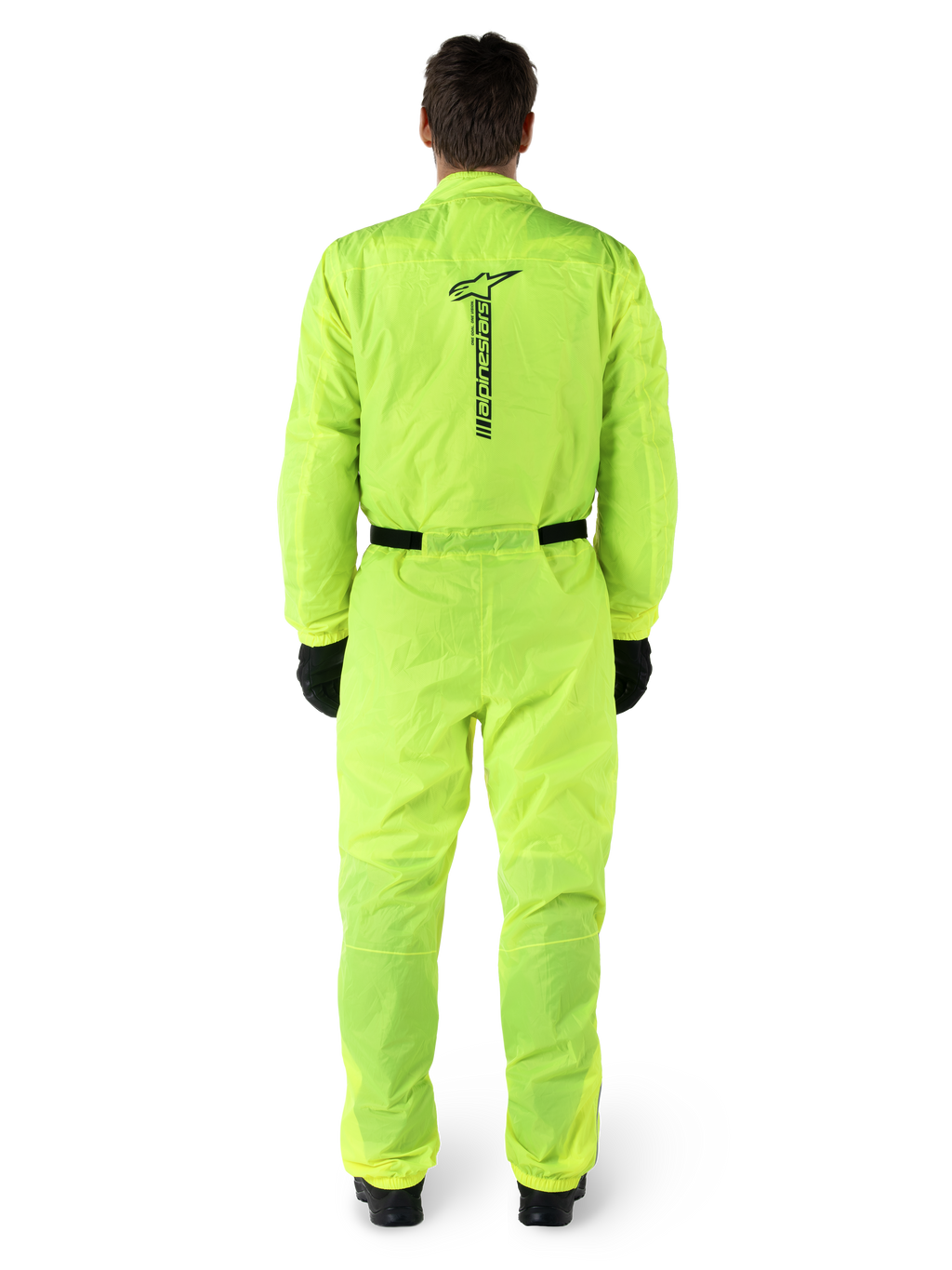 Alpinestars Hurricane Rain V2 Suit, One-piece Motorcycle Rain Suit, Yellow Fluo, back view featuring vertical black Alpinestars branding, elasticated waist and cuffs, worn with black gloves and boots, waterproof and wind-resistant riding gear