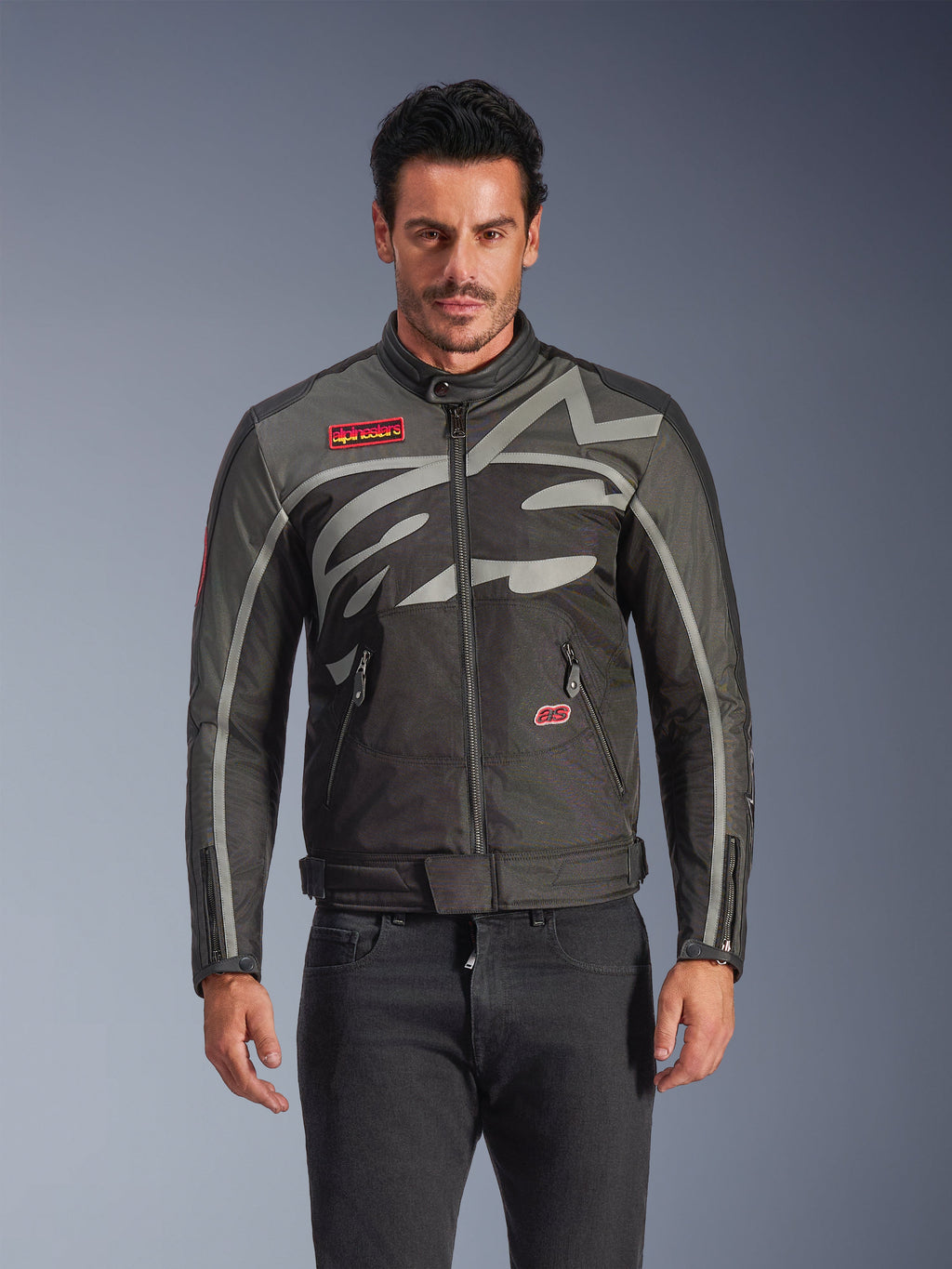 Alpinestars Axton Jacket, Men's Urban Motorcycle Jacket, Black and Anthracite with red accents, featuring a large wrap-around light gray graphic, red logo patches on the chest and pocket, front zipper and zippered cuffs, vintage-inspired racing design for street riding