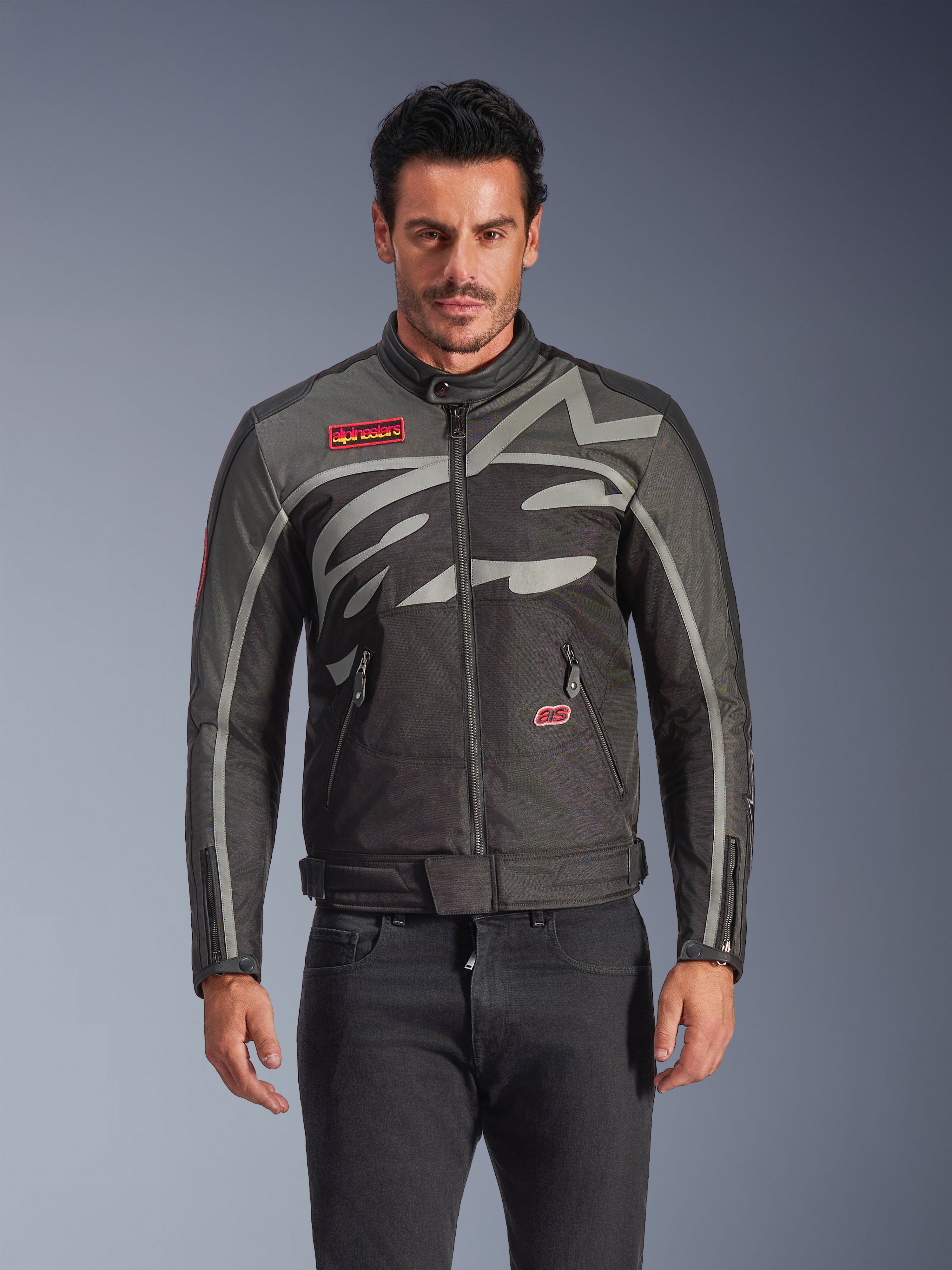 Alpinestars Axton Jacket, Men's Urban Motorcycle Jacket, Black and Anthracite with red accents, featuring a large wrap-around light gray graphic, red logo patches on the chest and pocket, front zipper and zippered cuffs, vintage-inspired racing design for street riding