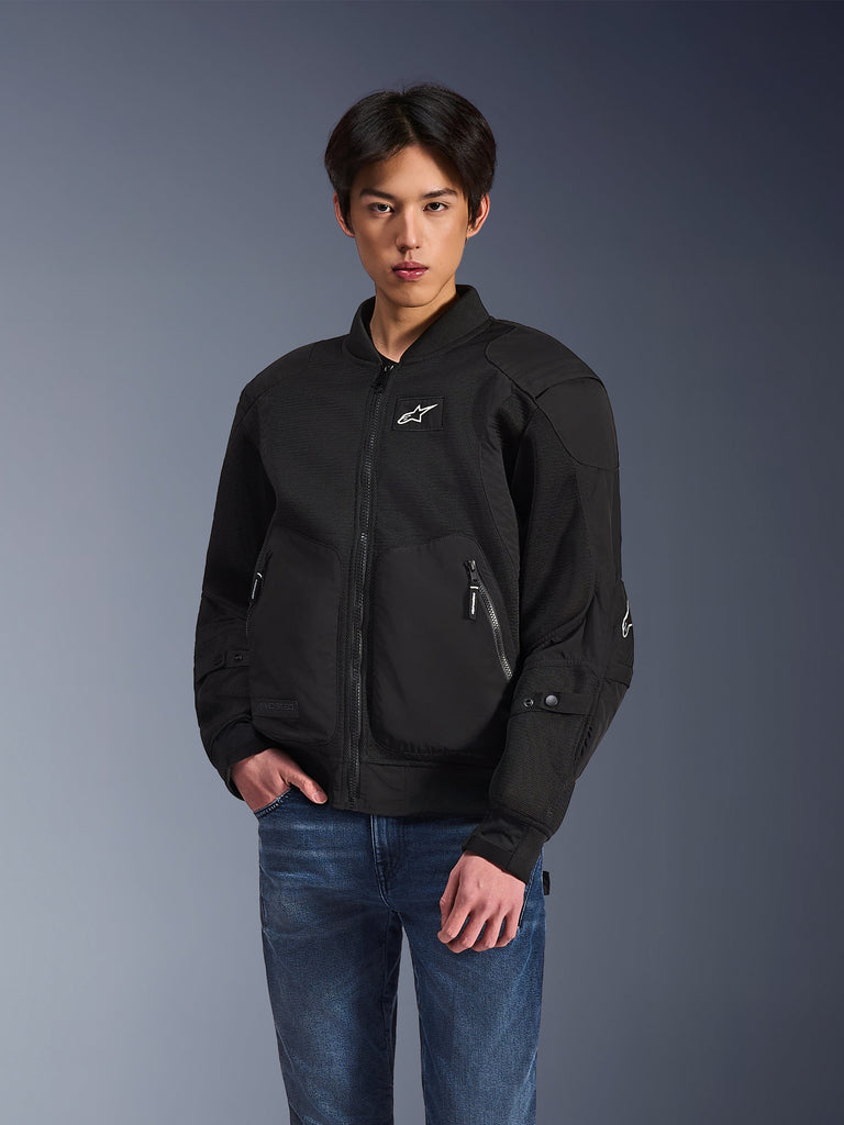 Alpinestars Flight Air Jacket, Black Urban Motorcycle Jacket, worn by a man with blue jeans, featuring a bomber-style aesthetic with mesh panels, front zipper, and white logo on the chest, designed for hot-weather city riding