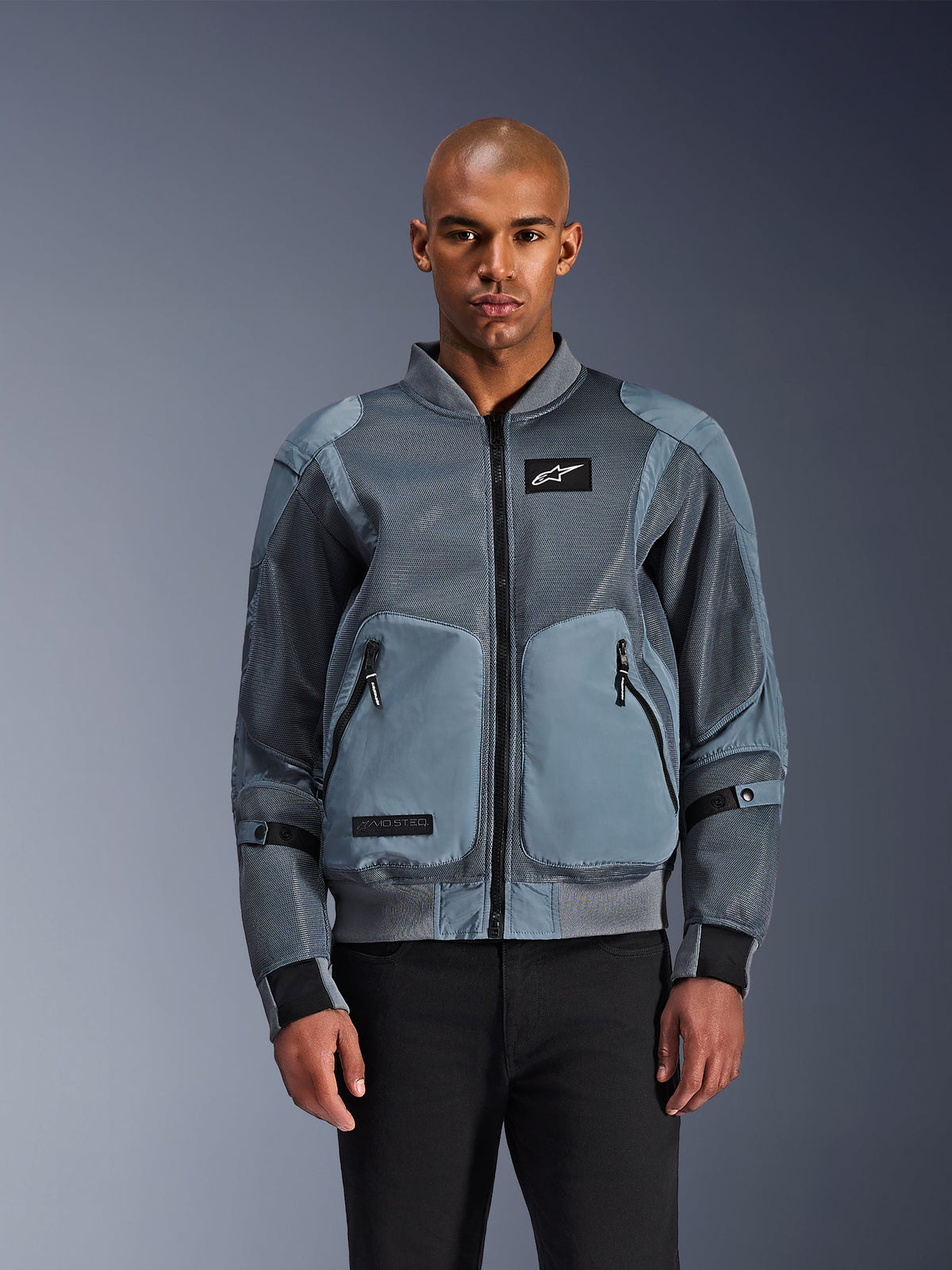 Alpinestars Flight Air Jacket, Urban Bomber Motorcycle Jacket, Storm Gray, features 3D mesh ventilation panels and white Astars logo patch, worn by male model with black pants, contemporary urban riding apparel