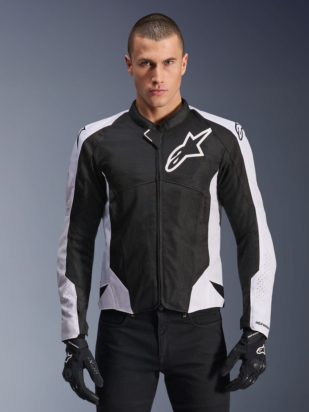 Alpinestars Viper Air V4 Jacket, Motorcycle Racing Jacket, Black and White, worn by rider, tech mesh and textile construction with white shoulder panels, prominent star logo on chest, sport performance design, paired with black riding gloves
